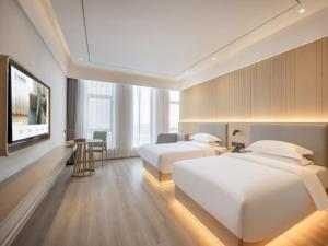 a hotel room with two beds and a flat screen tv at Deep Sleep Hotel Hangzhou Dajiang East Haide Xingang Center in Hangzhou
