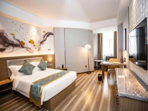 Una habitación de hotel con una cama grande y un televisor. en GreenTree Eastern Hotel Bengbu Huaishang Guogou Plaza Lijing Tiancheng, en Bengbu