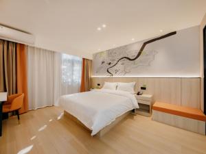 Un dormitorio con una gran cama blanca y un escritorio. en Vatica Hotel Shuyang Central Mall Nanjing Road, en Shuyang