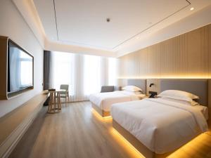 a hotel room with two beds and a flat screen tv at Deep Sleep Hotel Hangzhou Dajiang East Haide Xingang Center in Hangzhou