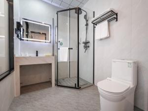 a bathroom with a shower and a toilet and a sink at GreenTree Inn Express Hotel Suzhou Taicang West Nanjing Road in Taicang