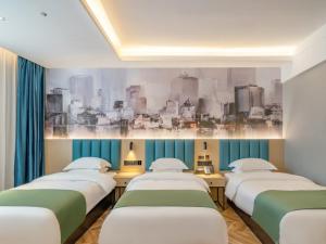 een rij van vier bedden in een kamer bij GreenTree Inn Express Hotel Changzhou Wujin Economic Development Zone Qishuyan Yaoguan in Changzhou