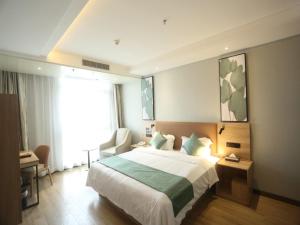 a hotel room with a large bed and a window at GreenTree Inn Anqing East Yingbin Road High-Speed Railway Station in Anqing