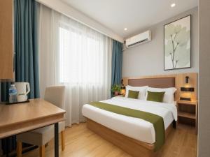 Habitación de hotel con cama grande y escritorio. en GreenTree Inn Express Hotel North Huaihai Road, en Huai'an