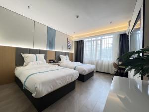 a hotel room with two beds and a large window at VX Hotel Anhui Suzhou Dangshan Zhongyuan Road in Dangshan