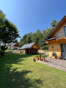 ein Haus mit einer Veranda und einem Garten mit Gras in der Unterkunft Drewniany Domek nad Doliną Dunajca in Zakliczyn