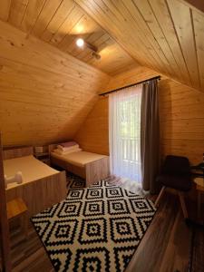 an attic room with a bed and a window at Drewniany Domek nad Doliną Dunajca in Zakliczyn