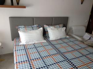 Una cama con dos almohadas encima. en Estúdio-Gambelas en Faro