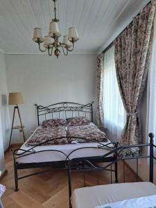een slaapkamer met een bed en een kroonluchter bij Vyšnia in Zarasai