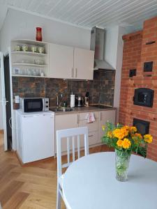a kitchen with a table with a vase of flowers at Vyšnia in Zarasai