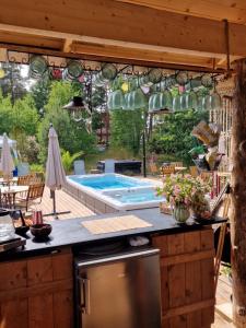an outdoor kitchen with a swimming pool and a patio at Woodstock B & B Studios in Bålsta