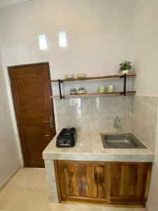 eine Küche mit einer Spüle und einer Theke in der Unterkunft LaGriya Guest House in Ketewel
