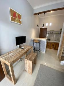sala de estar con mesa de madera y TV en LaGriya Guest House, en Ketewel