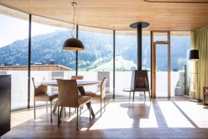 comedor con mesa y vistas a las montañas en Hotel Arlmont 4 Stern Superior, en Sankt Anton am Arlberg