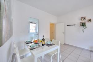 a white dining room with a white table and chairs at Central Love - Happy Rentals in Lugano