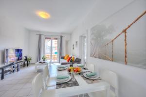 un comedor blanco con mesa y sillas en Central Love - Happy Rentals, en Lugano