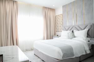 Un dormitorio con una gran cama blanca y una ventana en Le Levels Residency en Dammam