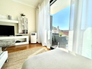 uma sala de estar com uma grande janela e uma televisão em Plaza Charming Flat em Santa Cruz