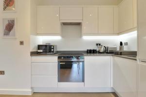 a kitchen with white cabinets and a stove top oven at Contractors l Holidays l Long Stays l Short Stays l WiFi l Remigro Short Lets in Saint Albans