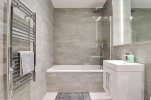 a bathroom with a tub and a sink and a shower at Contractors l Holidays l Long Stays l Short Stays l WiFi l Remigro Short Lets in Saint Albans +17 photos