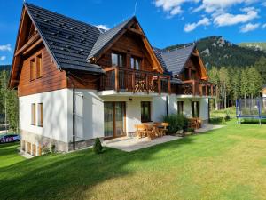 a house in the mountains with a yard at Darmilus apartmány in Demanovska Dolina