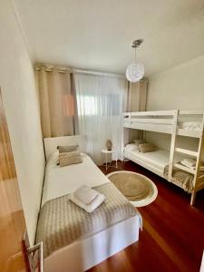 um quarto com 2 camas e um beliche em Plaza Charming Flat em Santa Cruz - Madeira