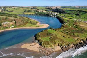 an aerial view of a beach and the ocean at Main House at White Horses, Bantham, South Devon with panoramic sea views across to Burgh Island in Bigbury on Sea
