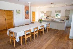a large kitchen with a table and chairs in a room at Main House at White Horses, Bantham, South Devon with panoramic sea views across to Burgh Island in Bigbury on Sea