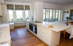 Una cocina con un mostrador y una mesa con un plato de comida. en Main House at White Horses, Bantham, South Devon with panoramic sea views across to Burgh Island, en Bantham