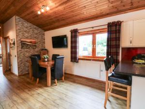 a kitchen and dining room with a table and chairs at Burnside Lodge in Fort William
