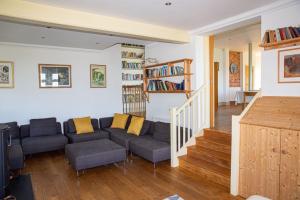 a living room with a couch and a book shelf at Main House at White Horses, Bantham, South Devon with panoramic sea views across to Burgh Island in Bigbury on Sea
