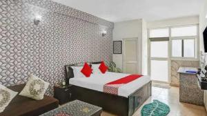 - une chambre avec un lit doté d'oreillers rouges dans l'établissement OYO Krishna Orchid Near Noida Sector 81 Metro Station, à Noida