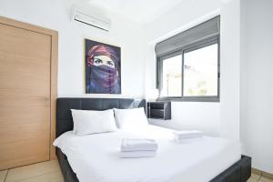 een slaapkamer met 2 bedden en een raam bij Perfect Location 2BR in Reines by HolyGuest in Tel Aviv