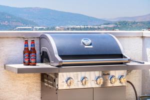 ein BBQ-Grill mit zwei Flaschen Bier in der Unterkunft לנפוש עם הנוף in Kefar H̱ananya