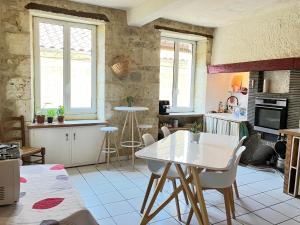 a kitchen with a white table and chairs at Au dessus des arcades in Vic-Fezensac