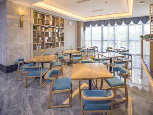 a dining room with tables and blue chairs at GreenTree Eastern Hotel Hainan Free Trade Port Jiangdong New District Meilan Airport in Haikou
