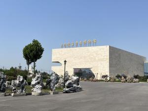 un edificio con un montón de estatuas delante de él en GreenTree Eastern Hotel Dezhou Pingyuan Debaiqi Stone Garden en Pingyuan