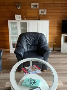 a black leather chair in a living room with a table at Einfach wohlfühlen, inklusive aktivCard Bayerischer Wald in Arrach