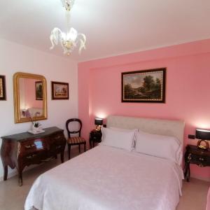 a bedroom with a white bed and pink walls at B&BYanet's Beautiful House in Civitavecchia