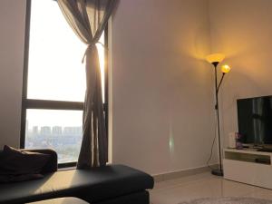a living room with a couch and a window at Islamic Santai Santai Homestay - Centrus Soho Cyberjaya in Cyberjaya