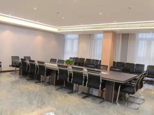 une salle de conférence avec une grande table et des chaises dans l'établissement GreenTree Eastern Hotel Dezhou Qingyun Yingcai Road Financial Building, à Dezhou