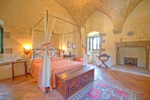 a bedroom with a canopy bed and a fireplace at Santa Flora by PosarelliVillas in Capolona