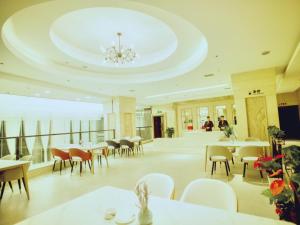 une salle à manger avec des tables et des chaises ainsi qu'un lustre dans l'établissement GreenTree Eastern Hotel Duyun Wen'an Jinmei Times Bus Station, à Yinzhan