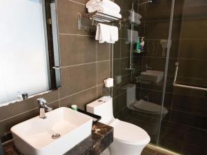 y baño con lavabo, aseo y ducha. en Geli Hotel Hefei Modian University Mengxi Town en Hefei
