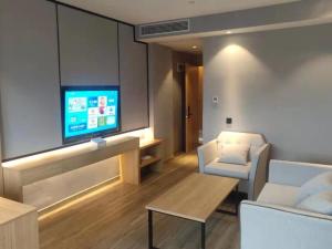 uma sala de estar com uma televisão, um sofá e uma mesa em GreenTree Eastern Hotel Tongling Yi'an Government em Xihu