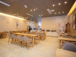 Un restaurante con mesas y sillas de madera en una sala. en GreenTree Eastern Hotel Bengbu Huaishang Guogou Plaza Lijing Tiancheng, en Bengbu