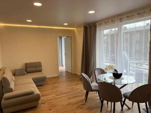 Seaside apartments في بالانغا: غرفة معيشة مع أريكة وطاولة زجاجية