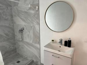 La salle de bains blanche est pourvue d'un lavabo et d'un miroir. dans l'établissement Seaside apartments, à Palanga