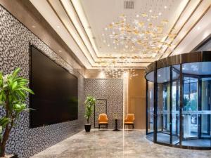 a lobby with two chairs and a large projection screen at GreenTree Eastern Hotel Tianjin Wuqing Wanda Plaza in Wuqing