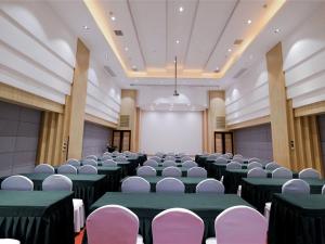 a large room with green tables and white chairs at GreenTree Eastern Hotel Jiaxing Jiangnan Moore Store in Jiaxing